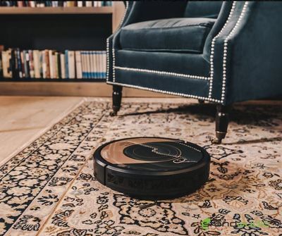 Robot aspirador sobre um tapete numa sala de estar