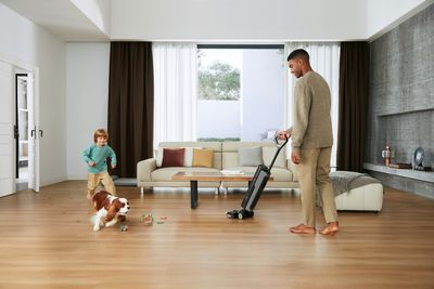 Família numa sala luminosa com aspirador moderno